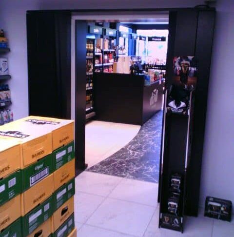 AirDoor Curve AirDoor Curve installation at Hanlon's Gala showing doorless entrance to walk-in beer fridge with customer access and product display